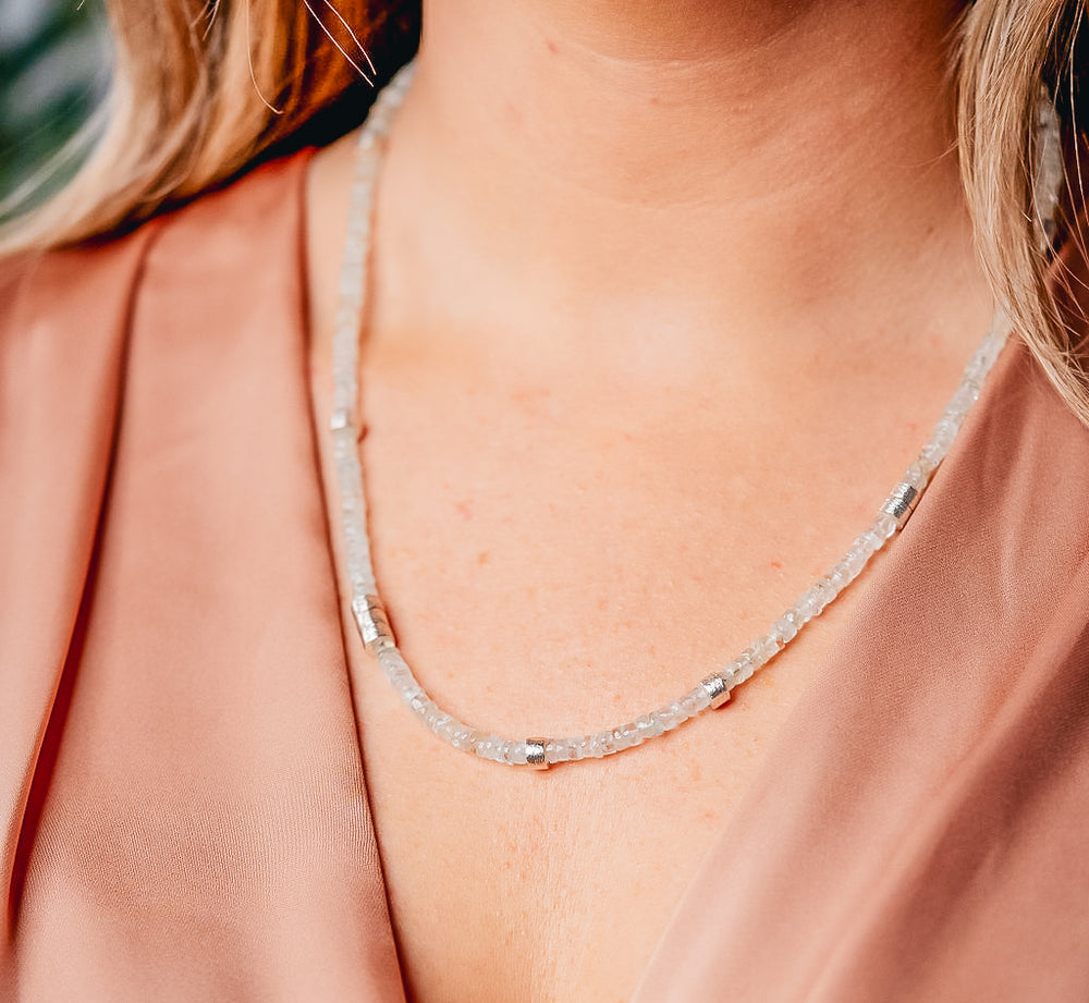 a model wearing an aquamarine bead necklace with silver accents 