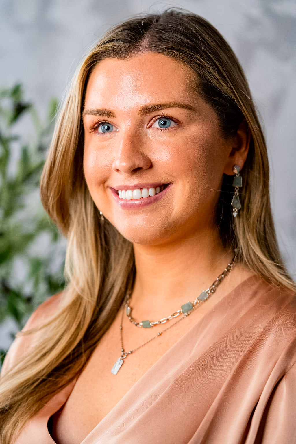 a model wearing a silver rectangle flower necklace on a delicate chain