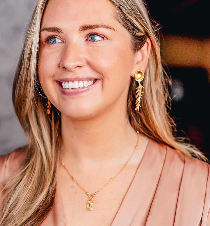 a model wearing a rectangle flower necklace on a delicate chain