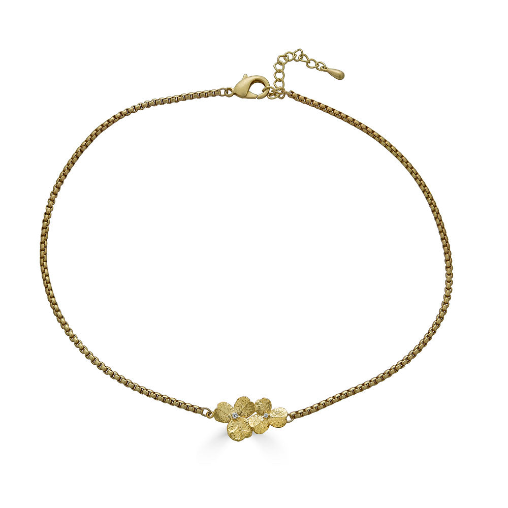 a bar necklace with a gold clover connector