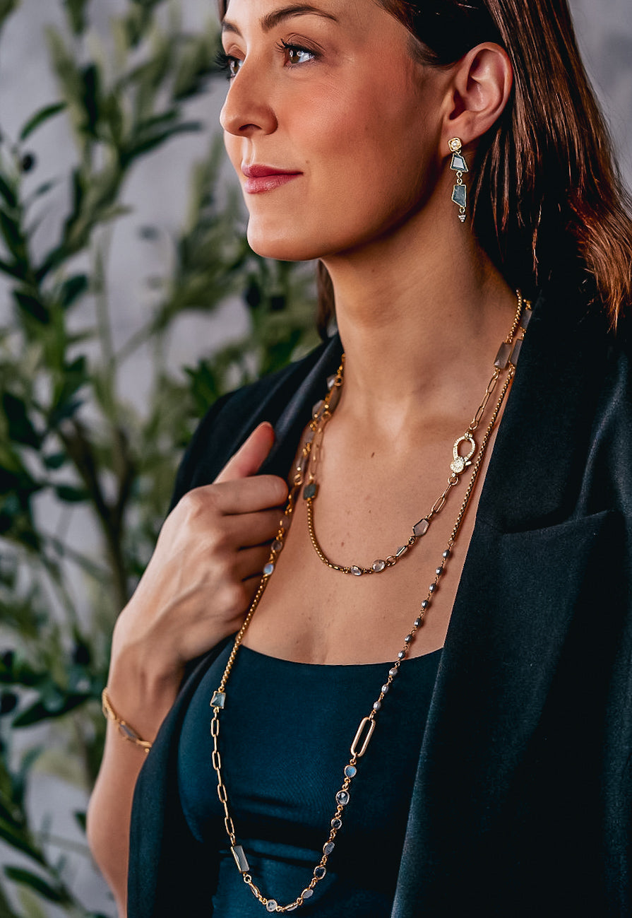 a modal wearing a mixed gemstone necklace with gray and rainbow moonstone, aquamarine and rice pearls.