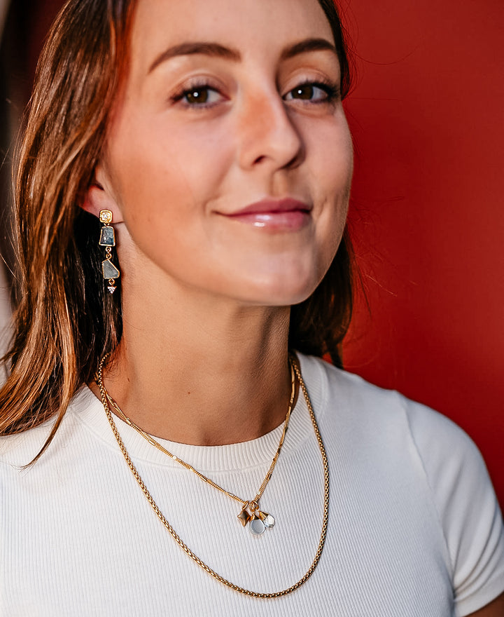 A model wearing gold aquamarine earrings