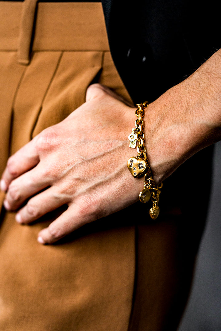 a model wearing a gold charm bracelet