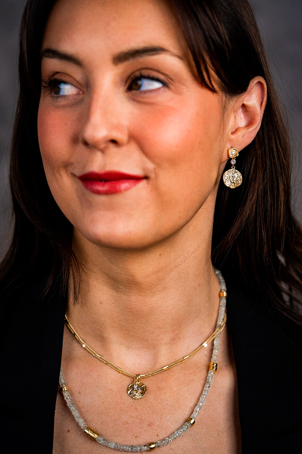 a model wearing a gold aquamarine bead necklace with gold accents.