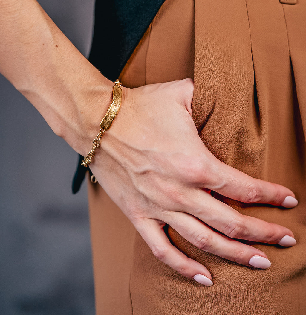 a model wearing a gold hammered connector bracelet