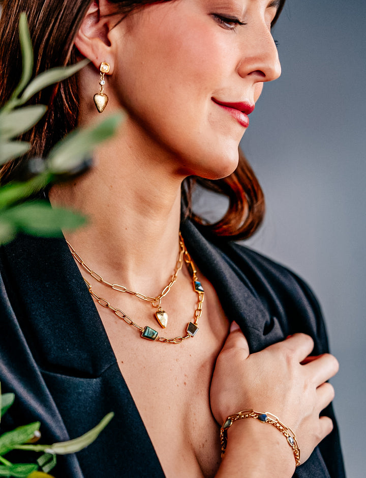 A model wearing gold heart dangle earrings