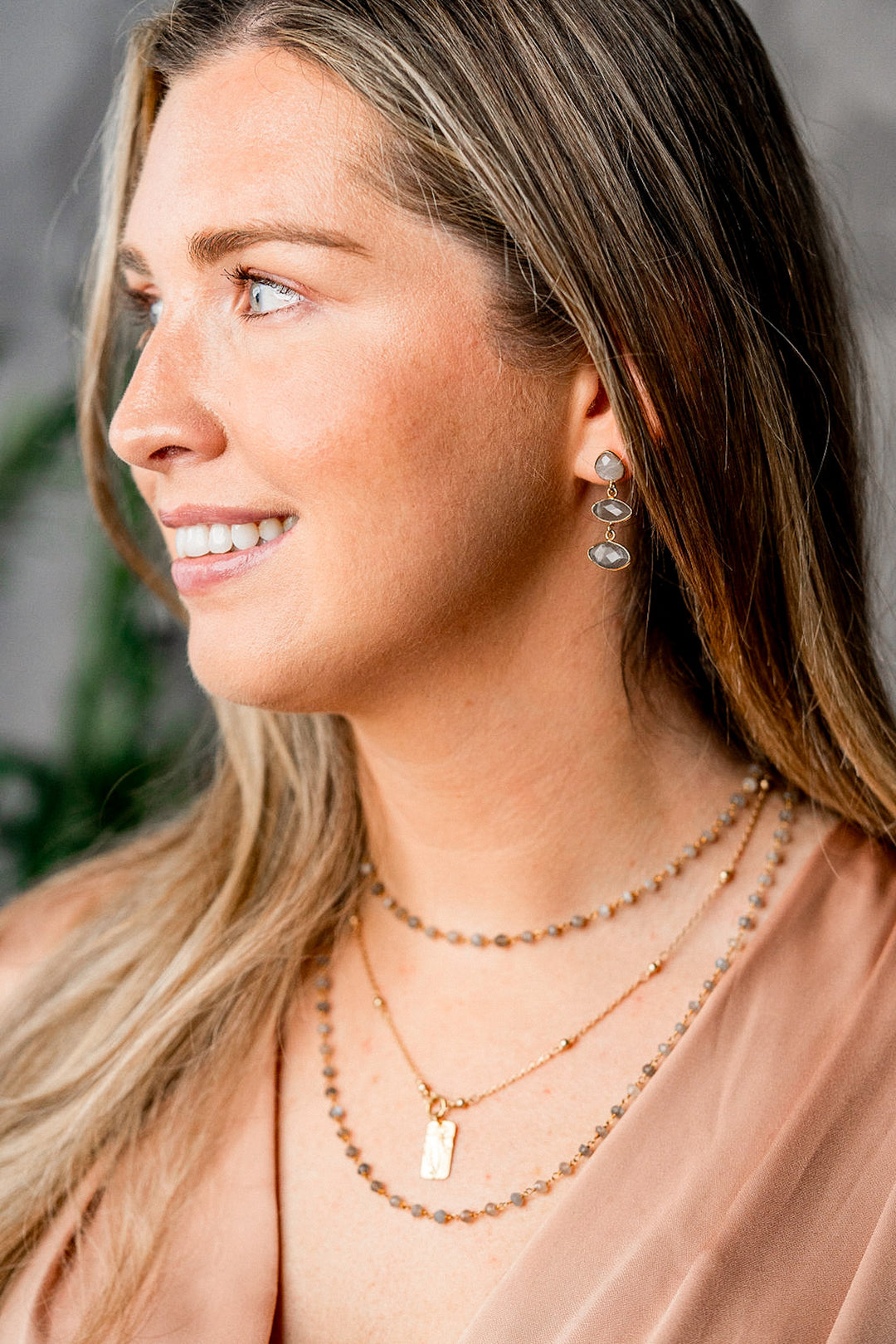 a model wearing a rectangle flower necklace on a delicate chain