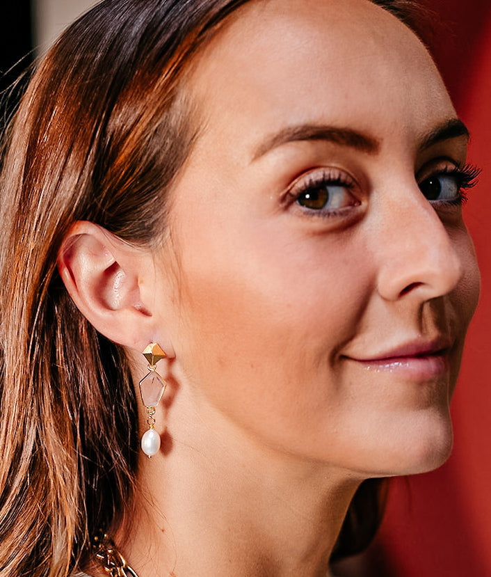 a model wearing rose quartz and pearl earrings