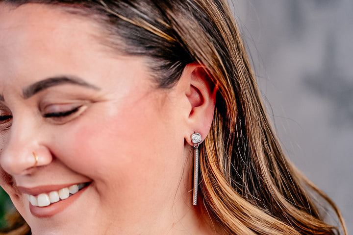 a model wearing a silver bar dangle earring