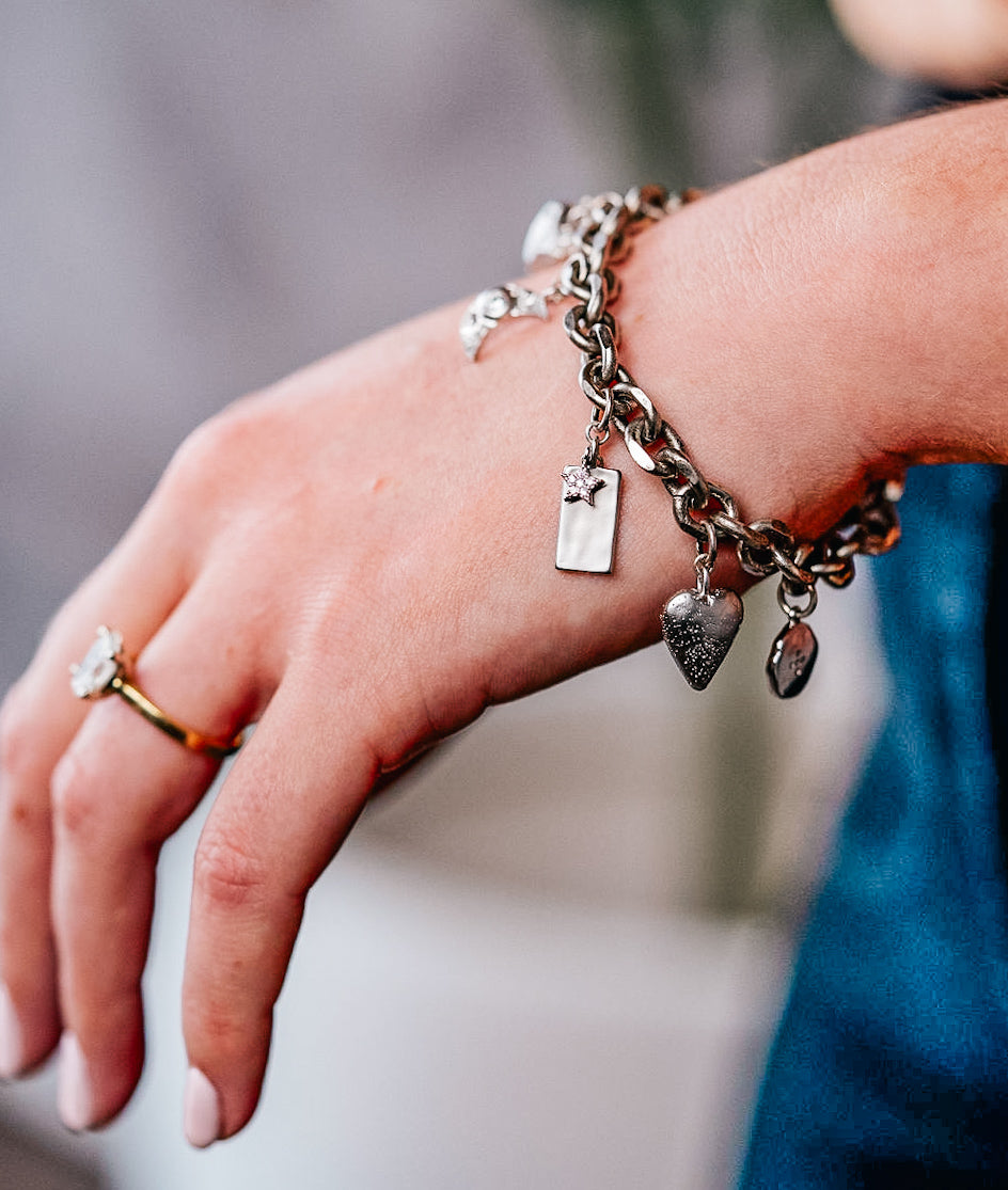 a model wearing a silver charm bracelet