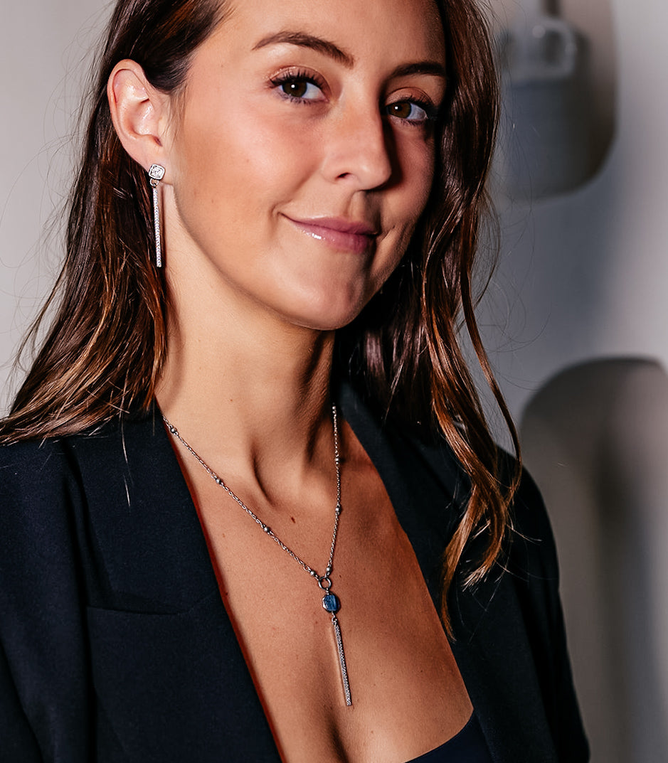 A model wearing a a silver bar dangle earring